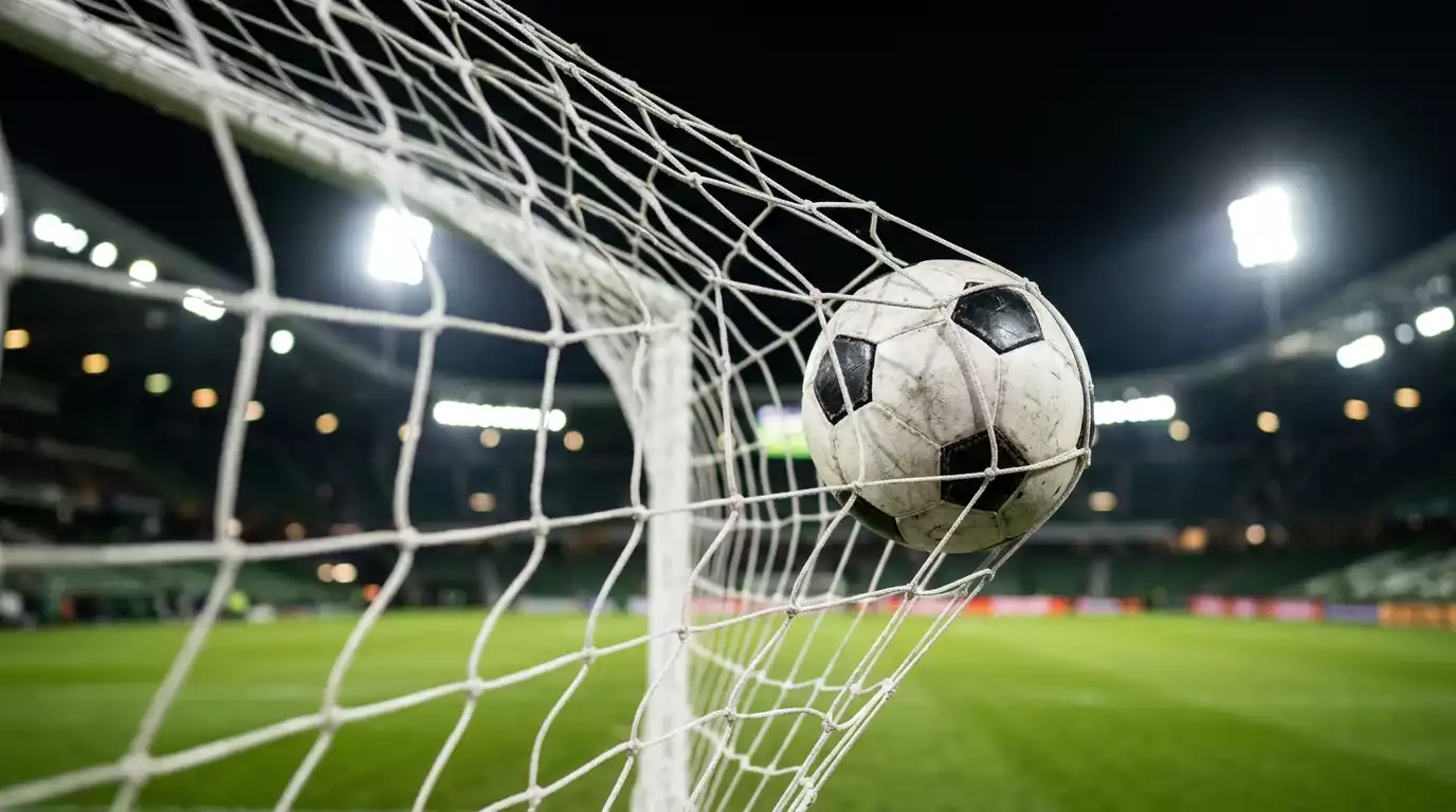 Detailbeeld van een voetbal in het doelnet onder stadionverlichting